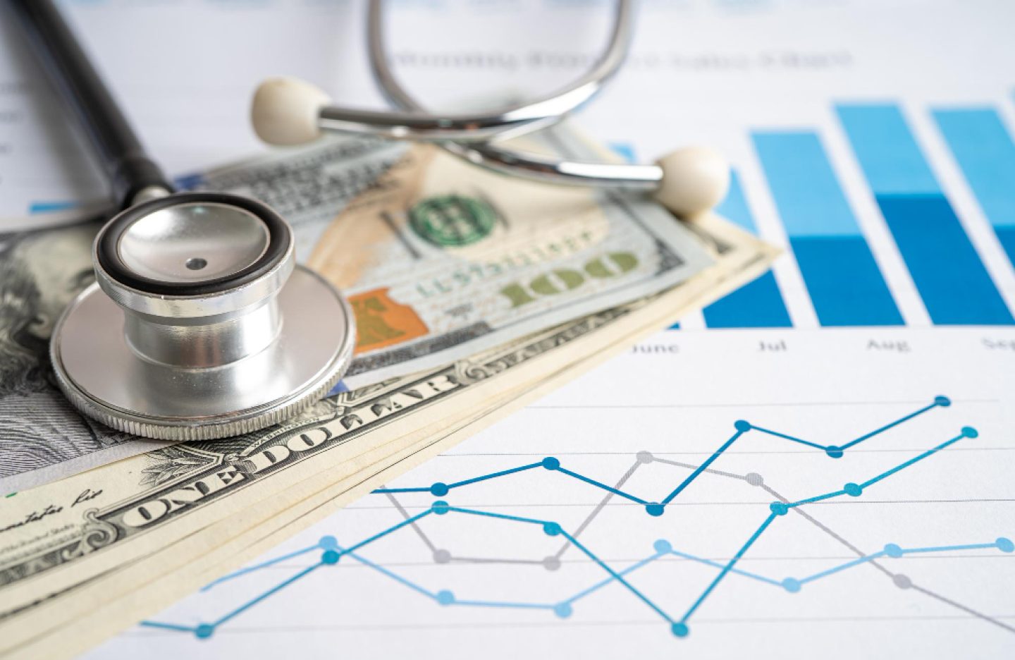 stethoscope-with-us-dollar-banknotes-chart-graph-paper-finance-account-statistics-investment-analytic-research-data-economy-business-company-concept